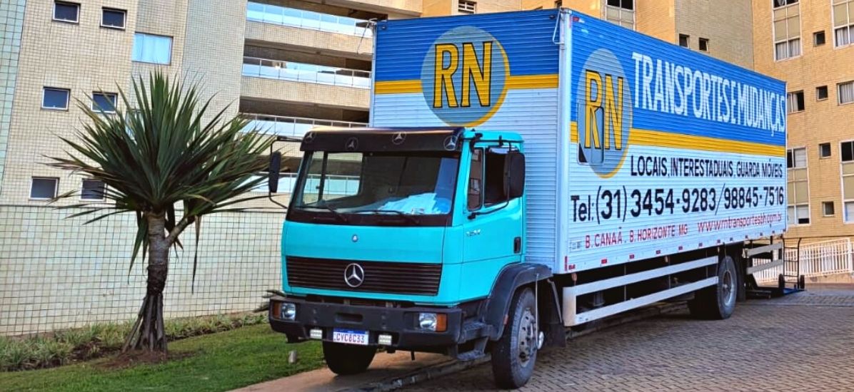 Profissional da RN Transportes ao lado do caminhão